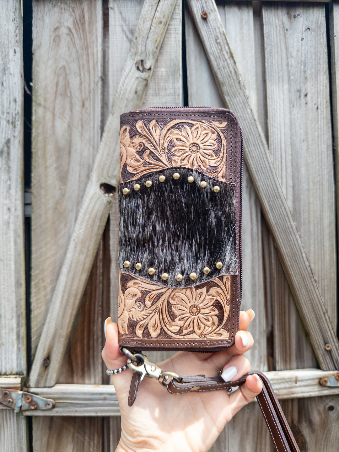 Back side of Family Tradition women’s western tooled leather wallet with Hair on Cowhide and gold studs black and white hide
