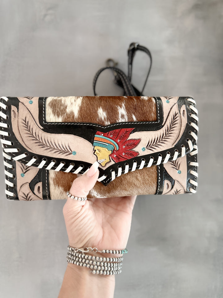 Handmade hair on cowhide and tooled leather clutch with hand painted Indian head centerpiece and feather tooling
