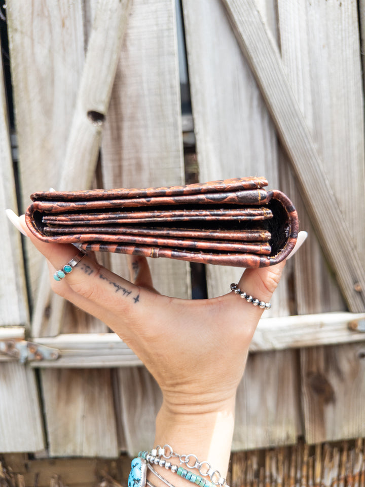 Croc-look embossed leather clutch wallet with whipstitch trim, shown at an angle