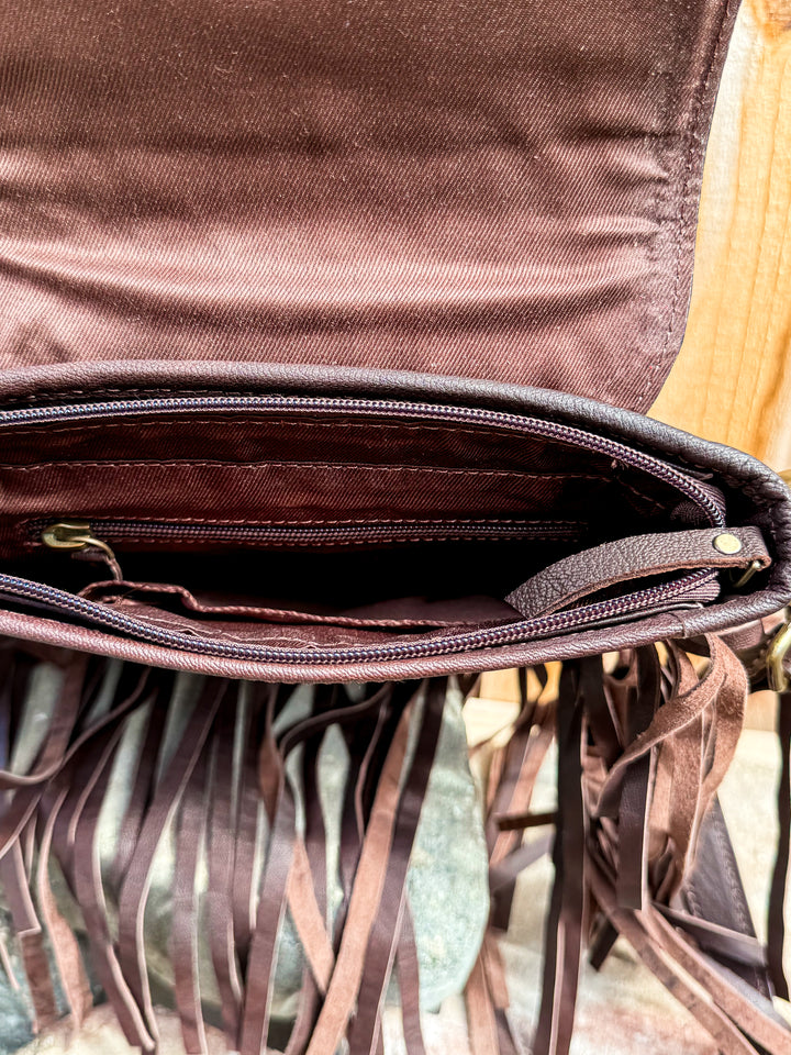 Inside view of brown fringe crossbody bag showing roomy interior storage
