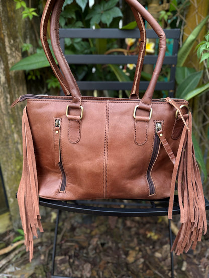 The Frontier Fringe Carryall : Cowhide, tooling, fringe, and function. Includes concealed carry pocket and two ways to wear