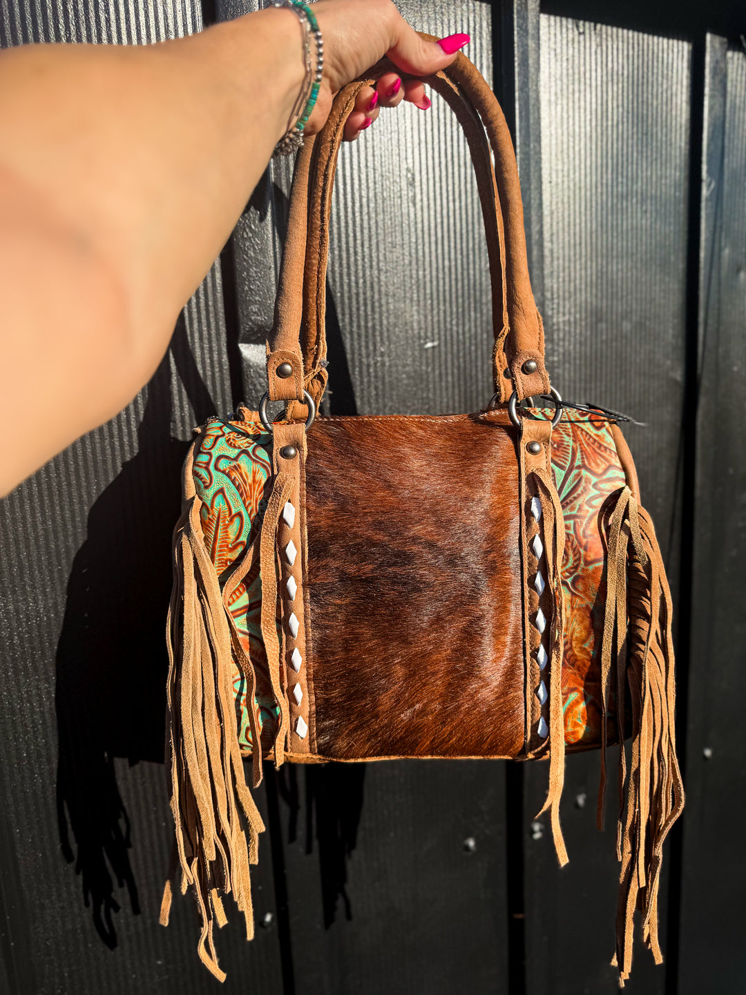 Strapped and stashed brindle cowhide concealed carry fringe speedy bag front view