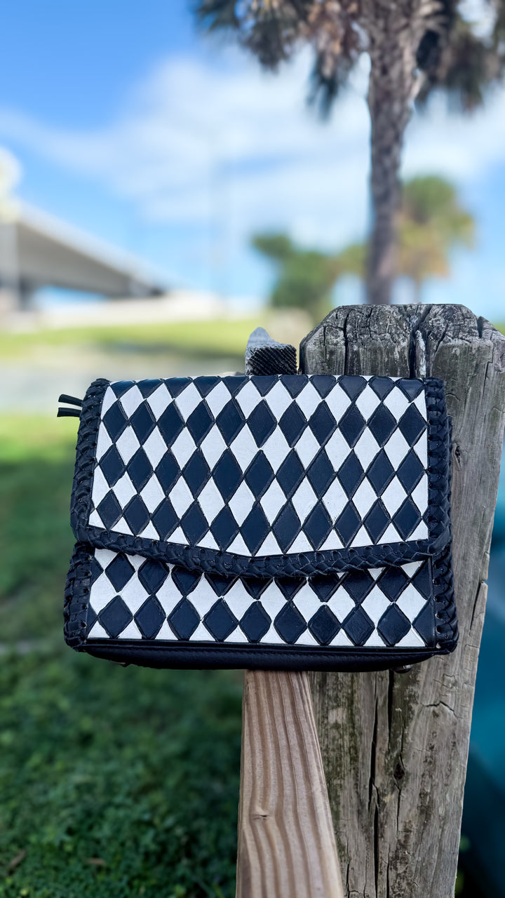 Speed Check After Dark black and white diamond-check tooled leather purse with black whipstitch edging and flap closure.