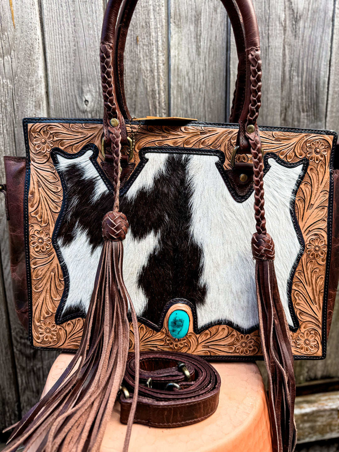 Cowhide and tooled leather concealed carry tote with braided handles and fringe tassels