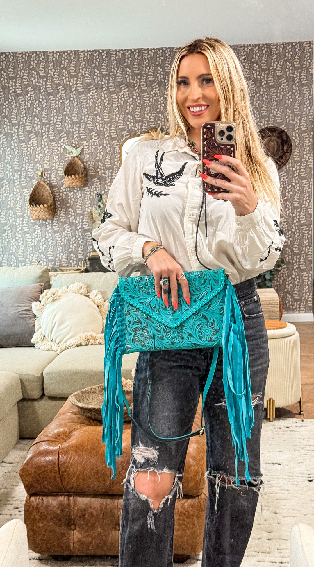 Woman modeling a bright turquoise blue tooled leather crossbody envelope purse with turquoise suede fringe  