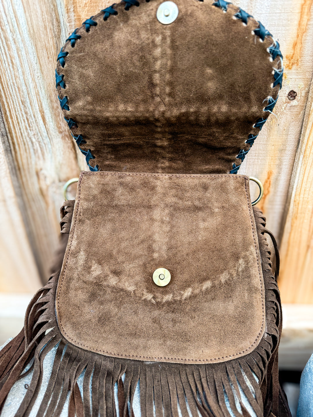 Inside view of suede fringe crossbody showing magnetic snap flap closure