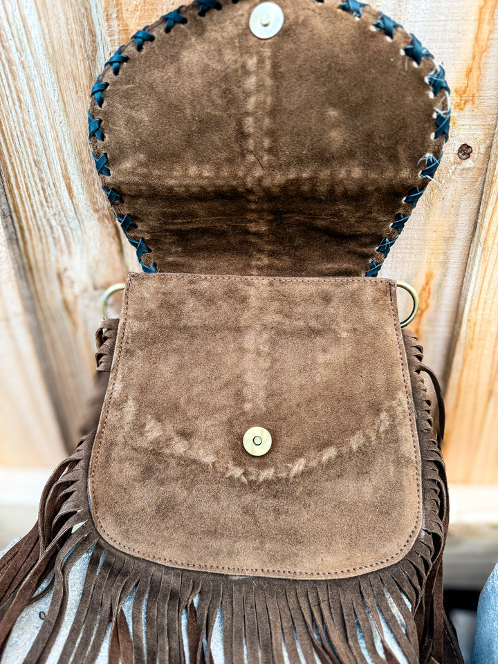 Inside view of suede fringe crossbody showing magnetic snap flap closure