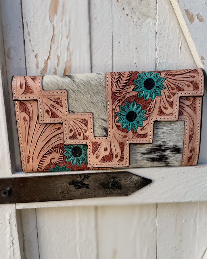 Western black speckled cowhide wallet with hand tooled leather floral pattern and turquoise bloom accents