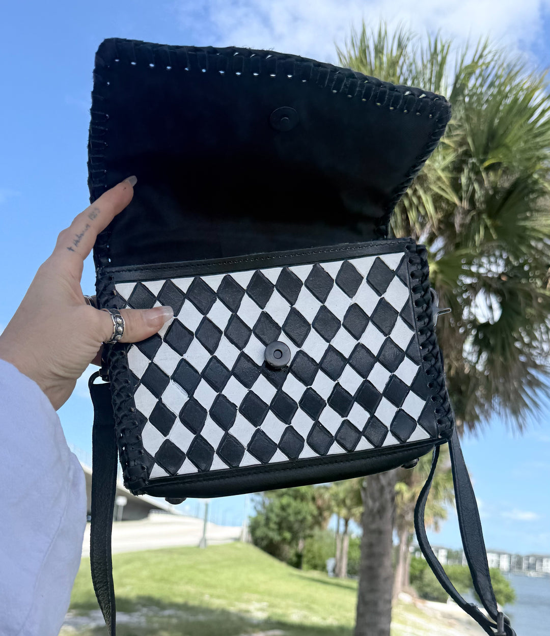 Speed Check After Dark purse with magnetic snap flap open, showing black leather lining and diamond-check front panel.