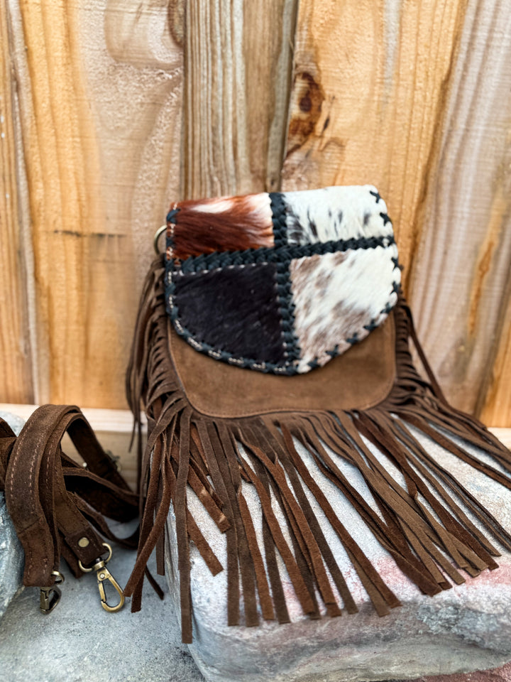 Brown suede fringe crossbody bag with patchwork cowhide flap and whipstitch edging