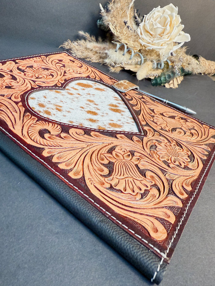 Cowhide heart and detailed tooling on handcrafted leather planning portfolio.