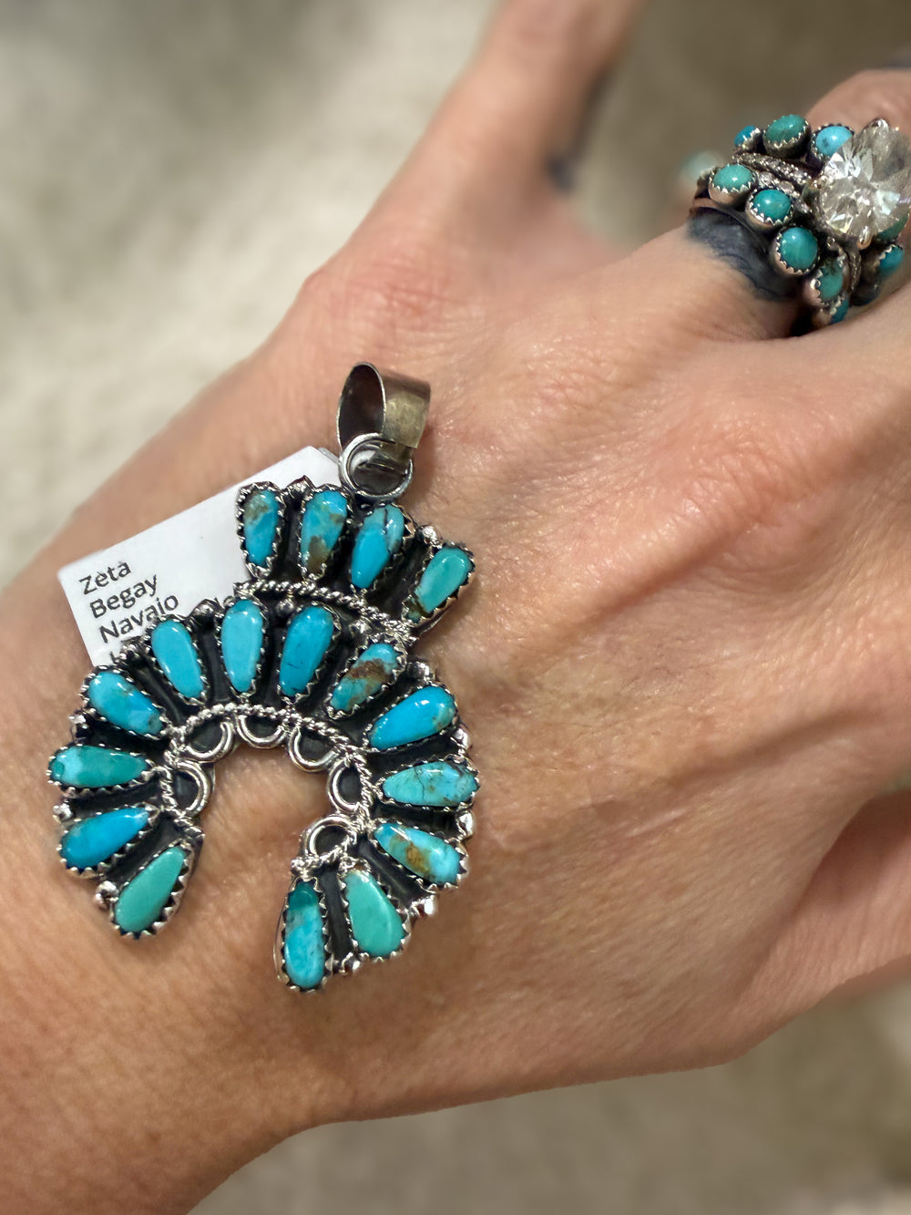 Zeta Begay Navajo turquoise naja pendant shown in hand sterling silver Kingman turquoise
