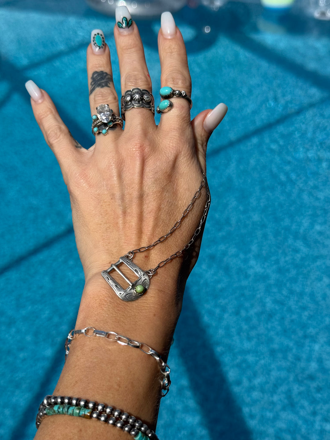 Native American sterling silver buckle necklace with turquoise
Handmade silver belt buckle pendant necklace
Western turquoise necklace on chain Layed on a hand in the sun showing size