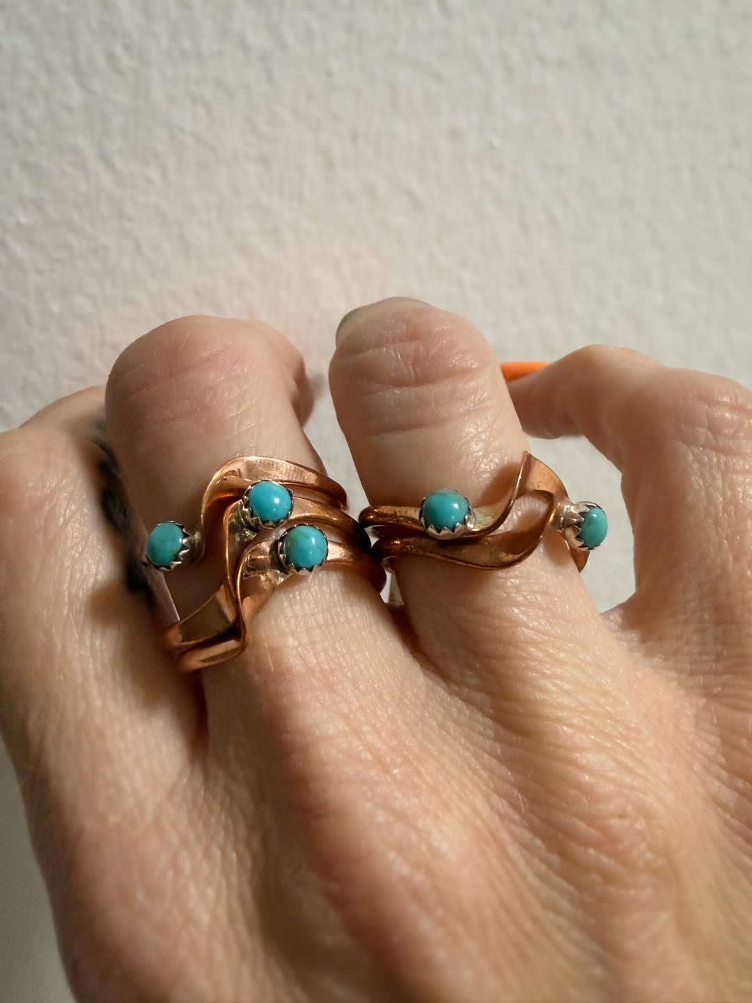 Copper and Kingman Turquosie stacker rings by Navajo artist Yolanda Skeets shown worn stacked on fingers 