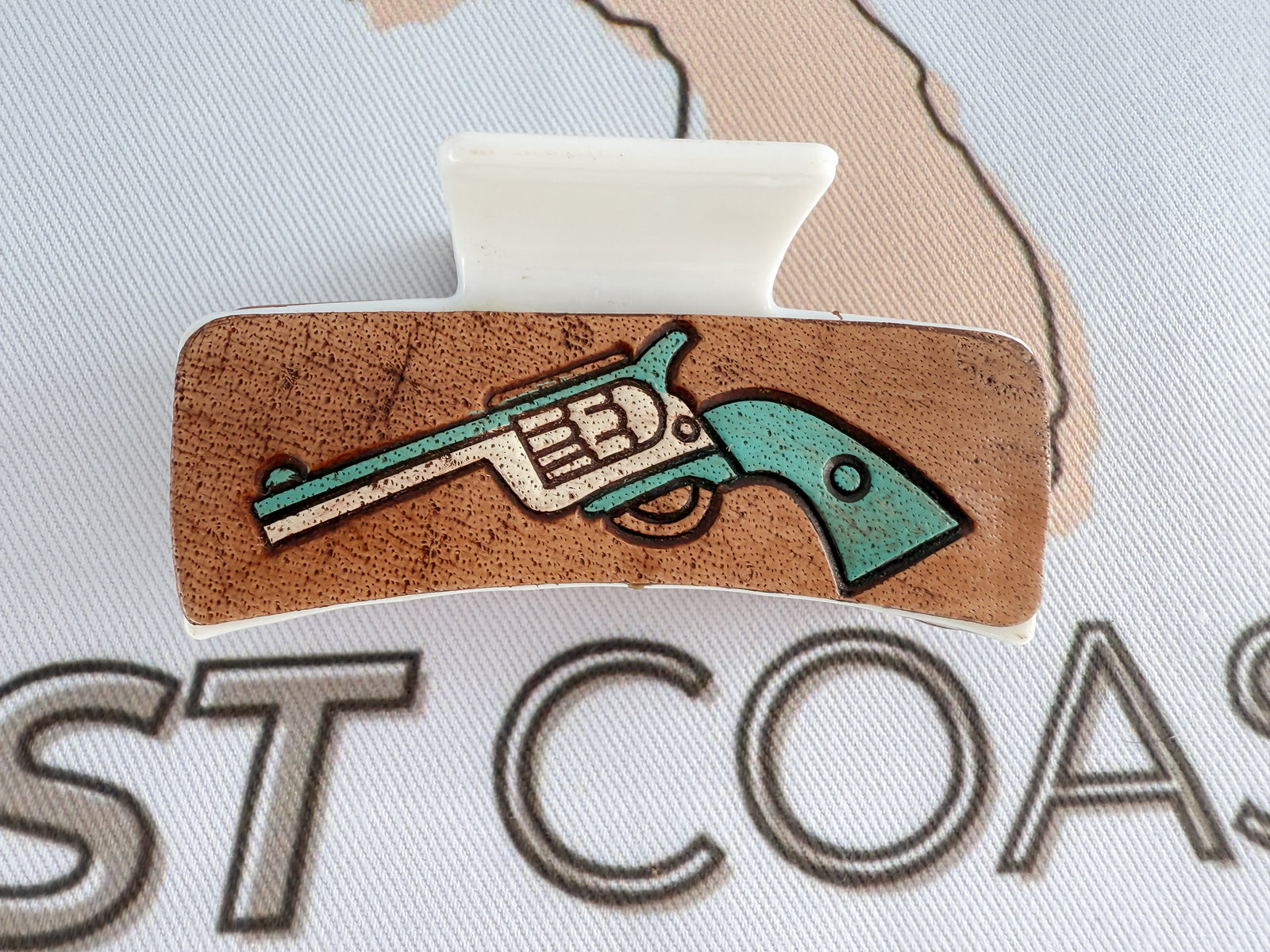 Cowgirl grit meets hair clip chic with hand-tooled, turquoise-detailed leather