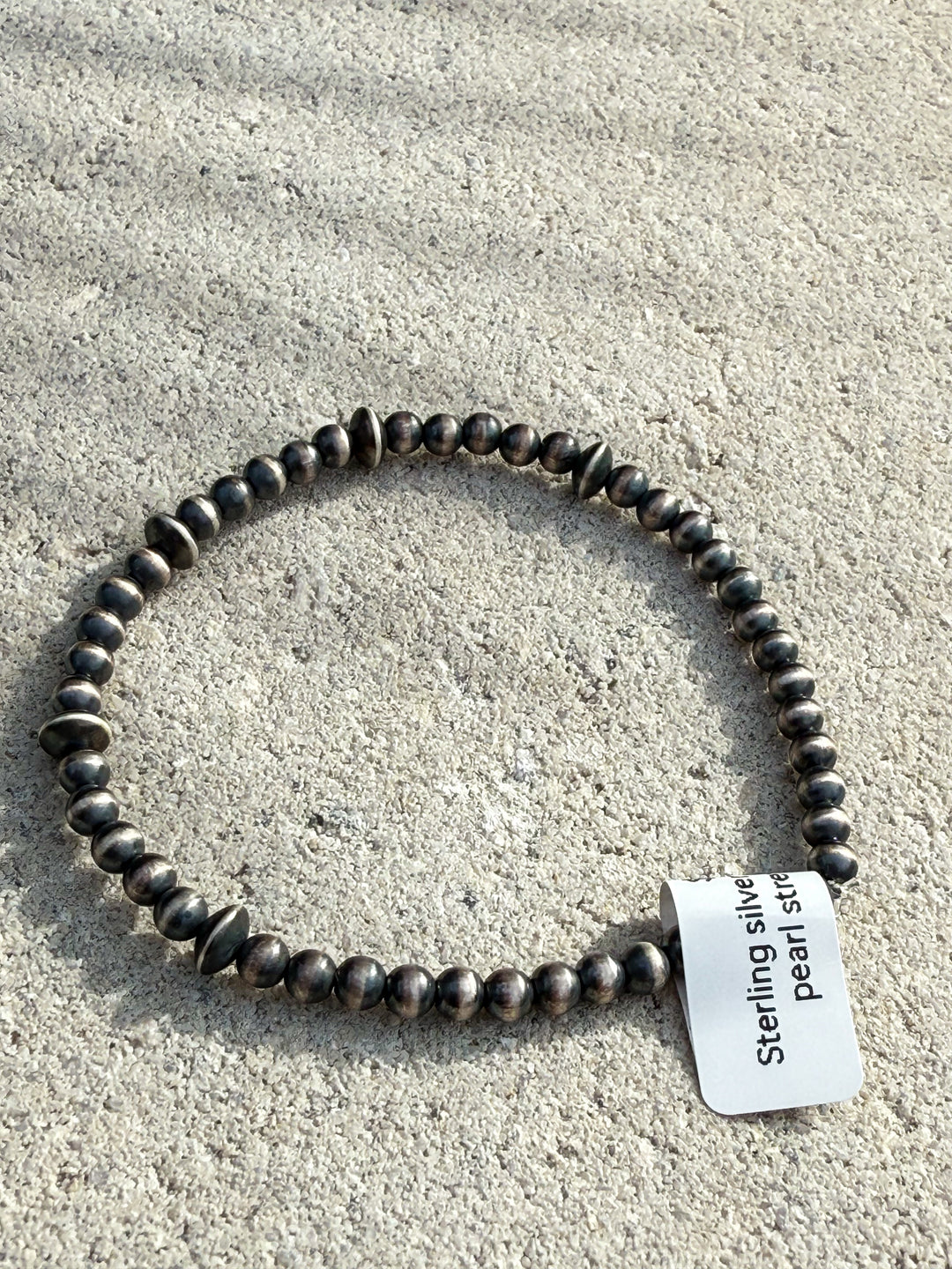 Oxidized desert pearl sterling silver stretch bracelet with 4mm ball and saucer beads on display tag