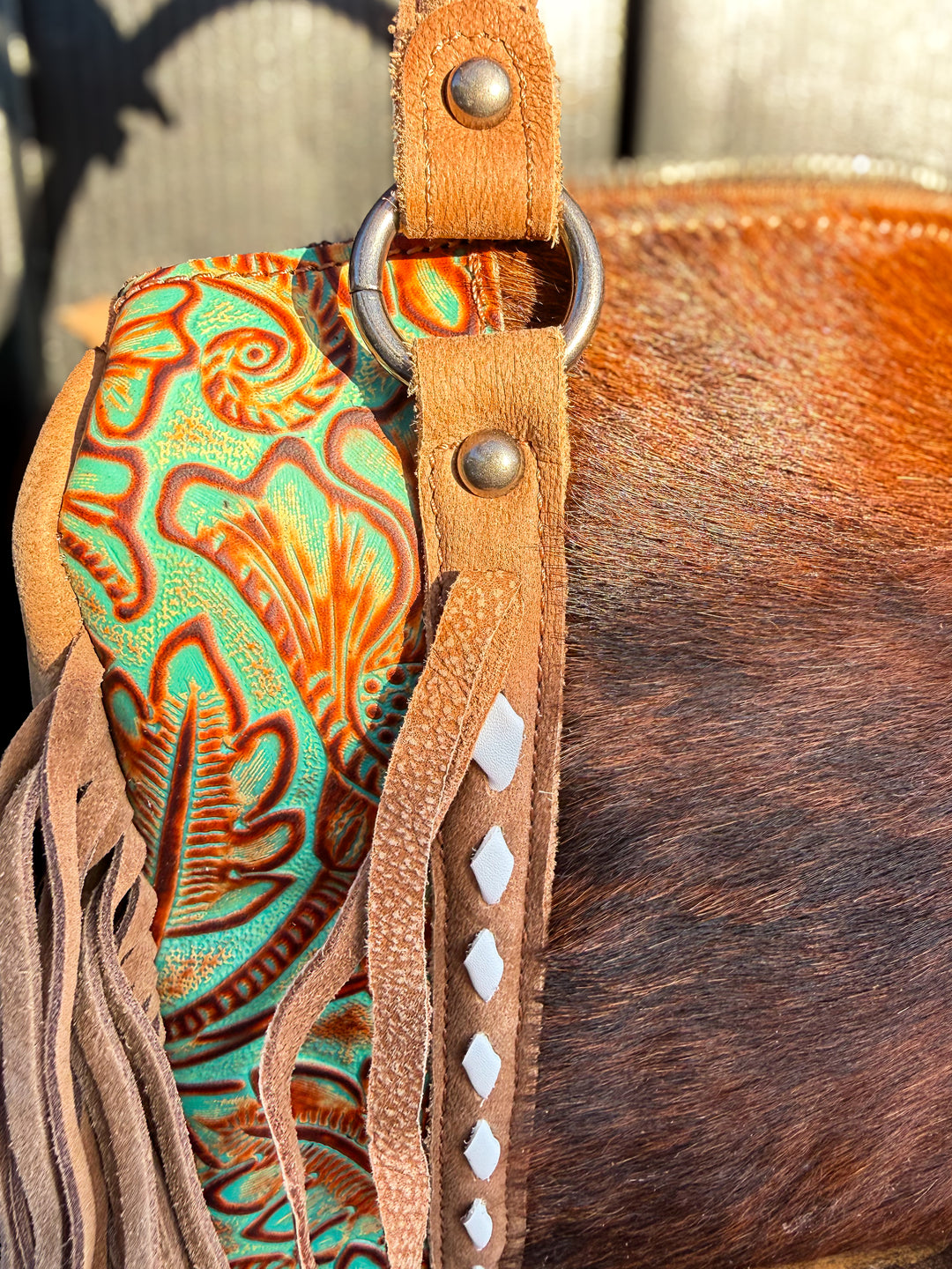 Green embossed leather tooling detail on western handbag