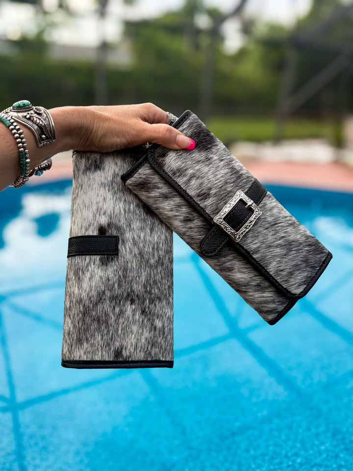 Salt and pepper Genuine cowhide clutch wallet with decorative silver buckle, black leather wristlet strap, magnetic closure, card slots, and phone storage.