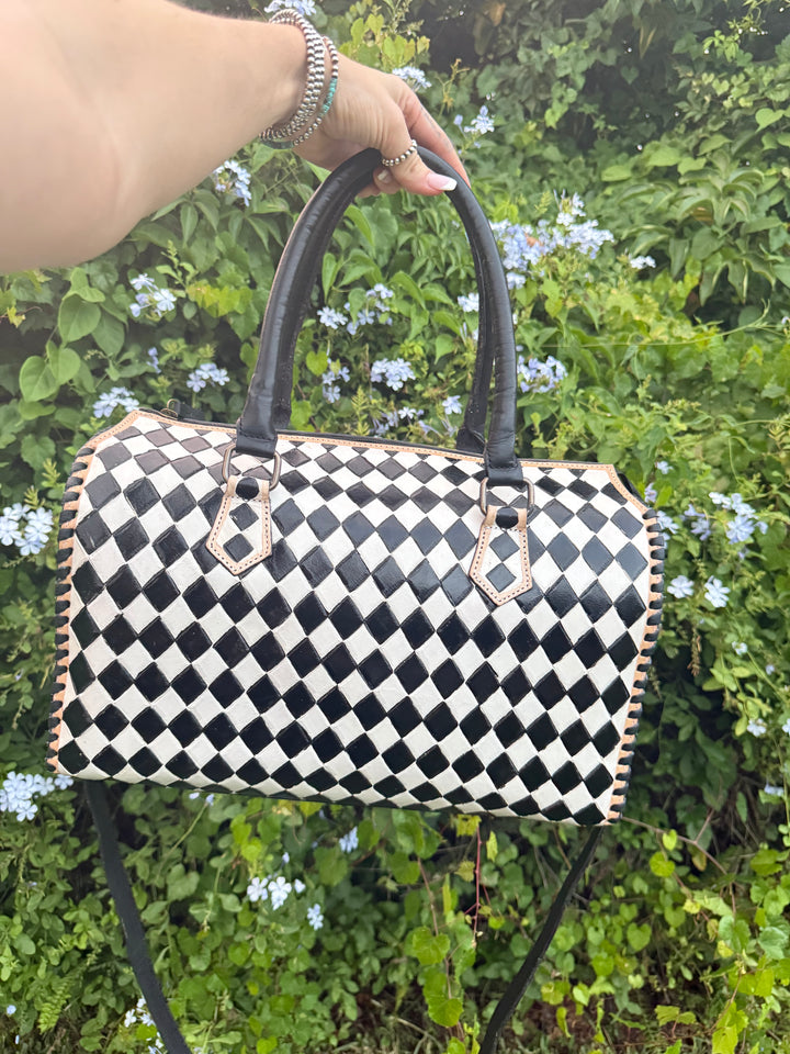 Handmade leather bowler bag in black and white checkered design with double handles.