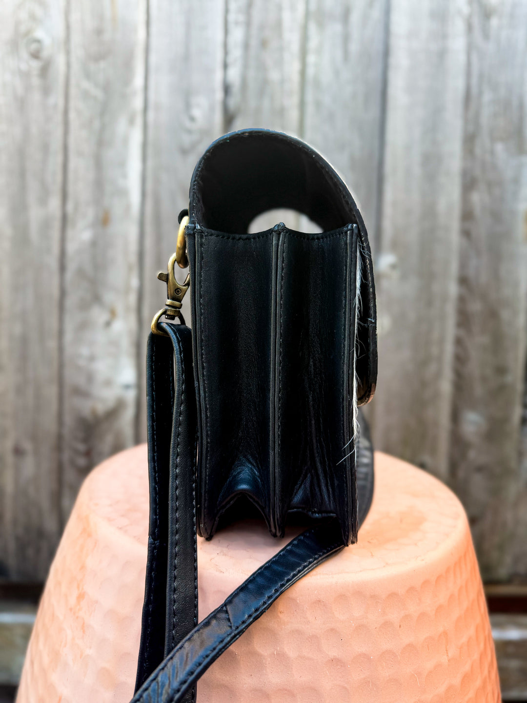 Side view of Speed Check side saddle crossbody showing structured compartments and brass hardware
