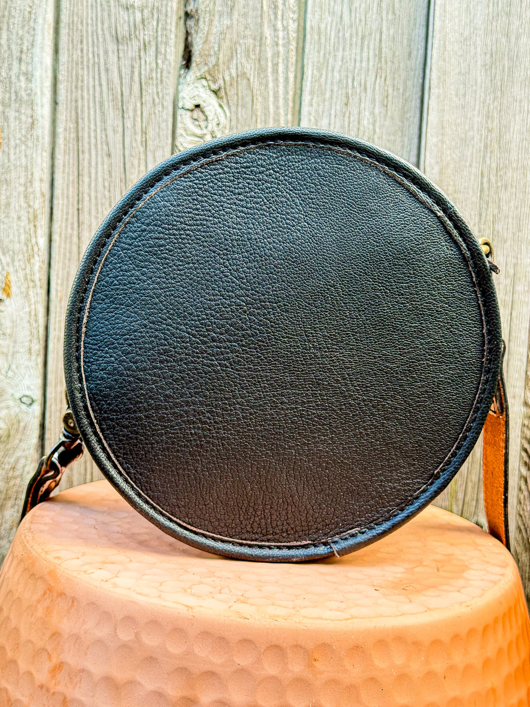Back view of black leather canteen crossbody bag with smooth pebbled leather
