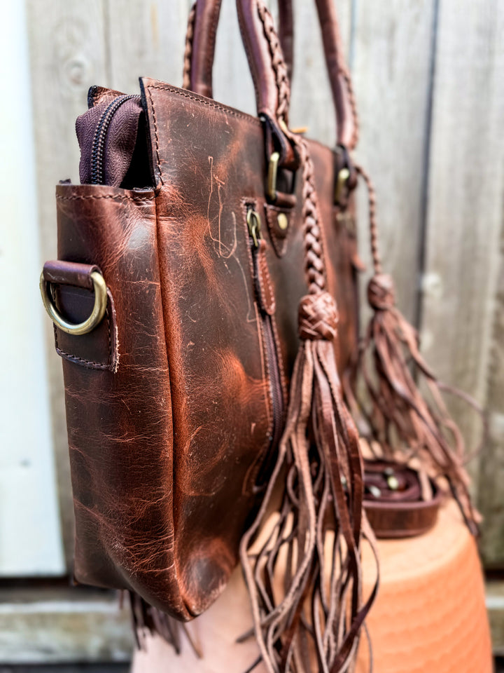 Side view of cowboy brown leather tote bag showing structured profile and brass hardware