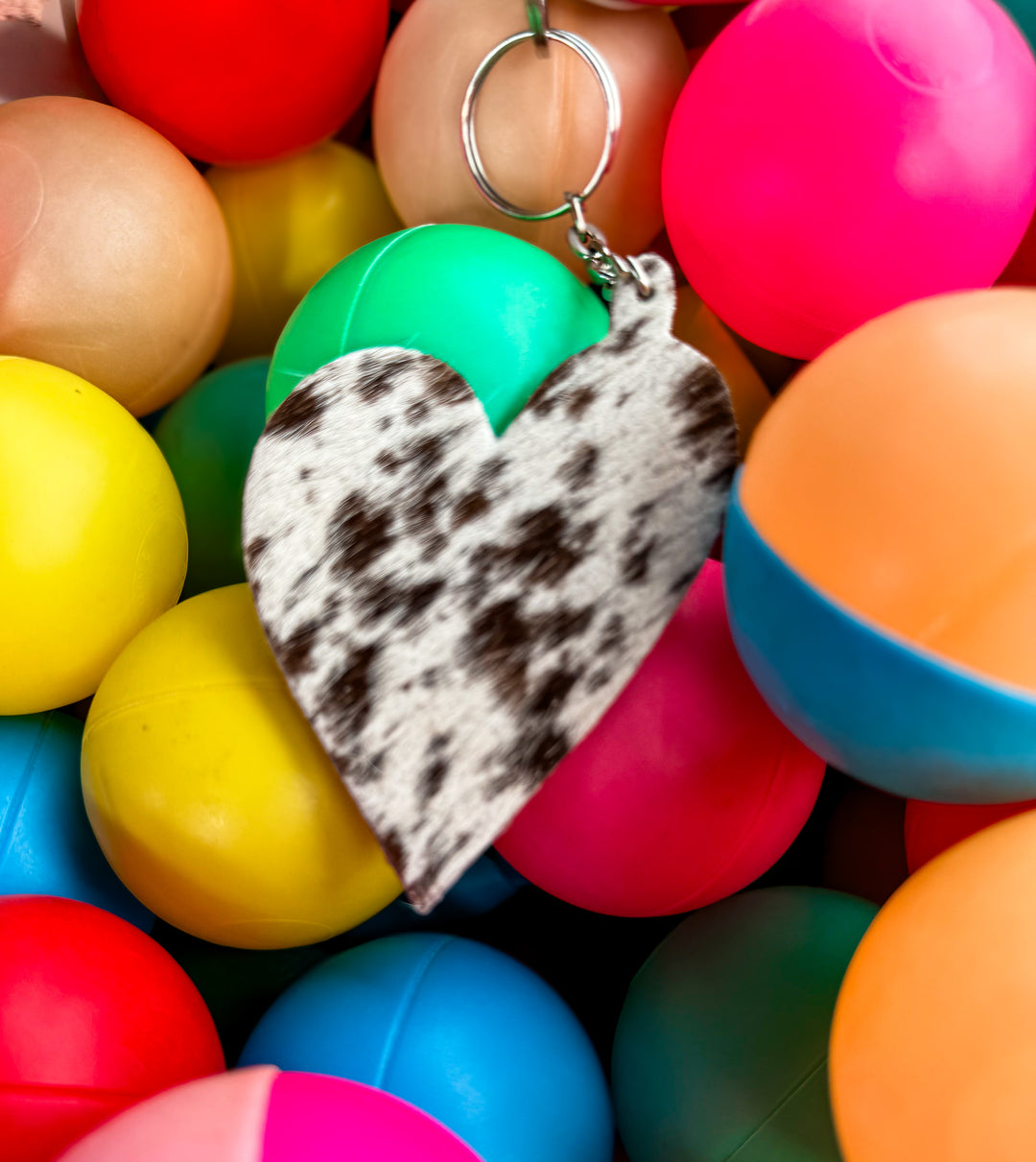 Western cowhide heart charm key ring accessory photographed on colorful background