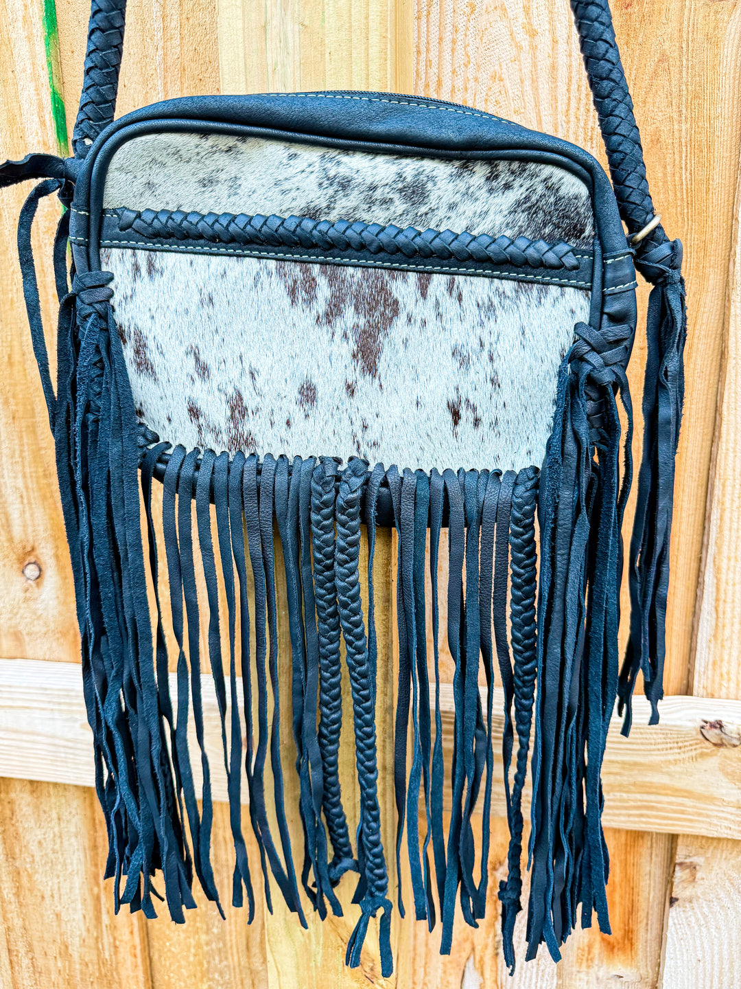 Black cowhide fringe crossbody bag with braided leather strap and details