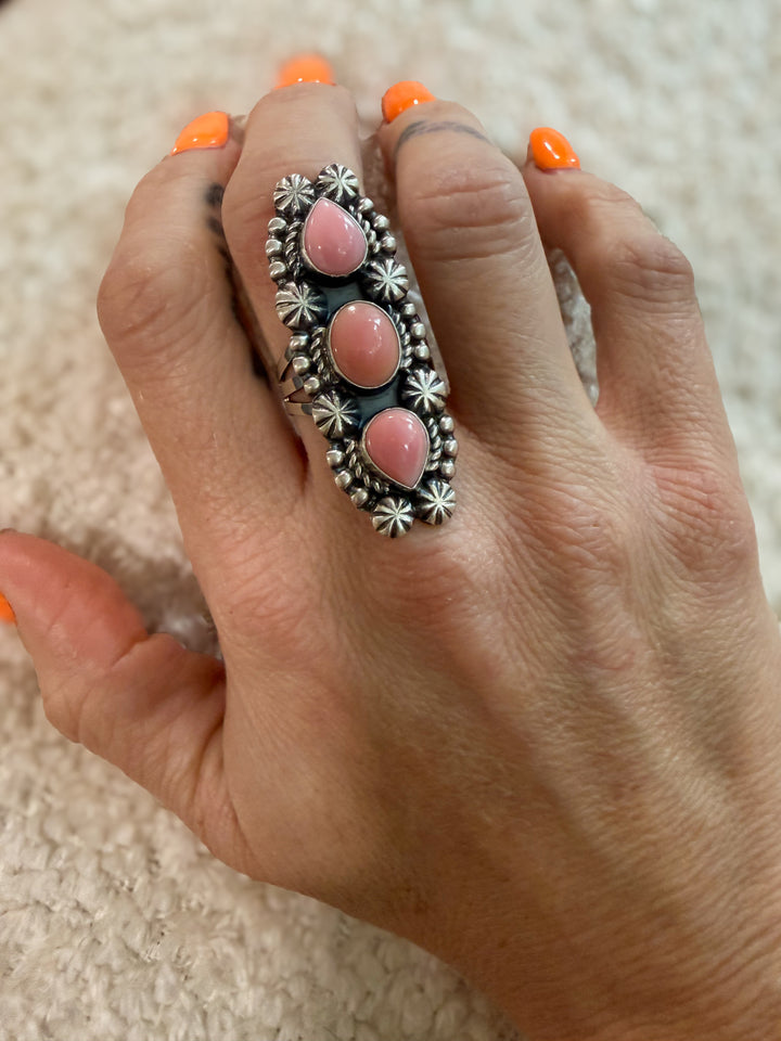 Measurement reference hand wearing Navajo pink conch cluster ring just under 2 inches long
