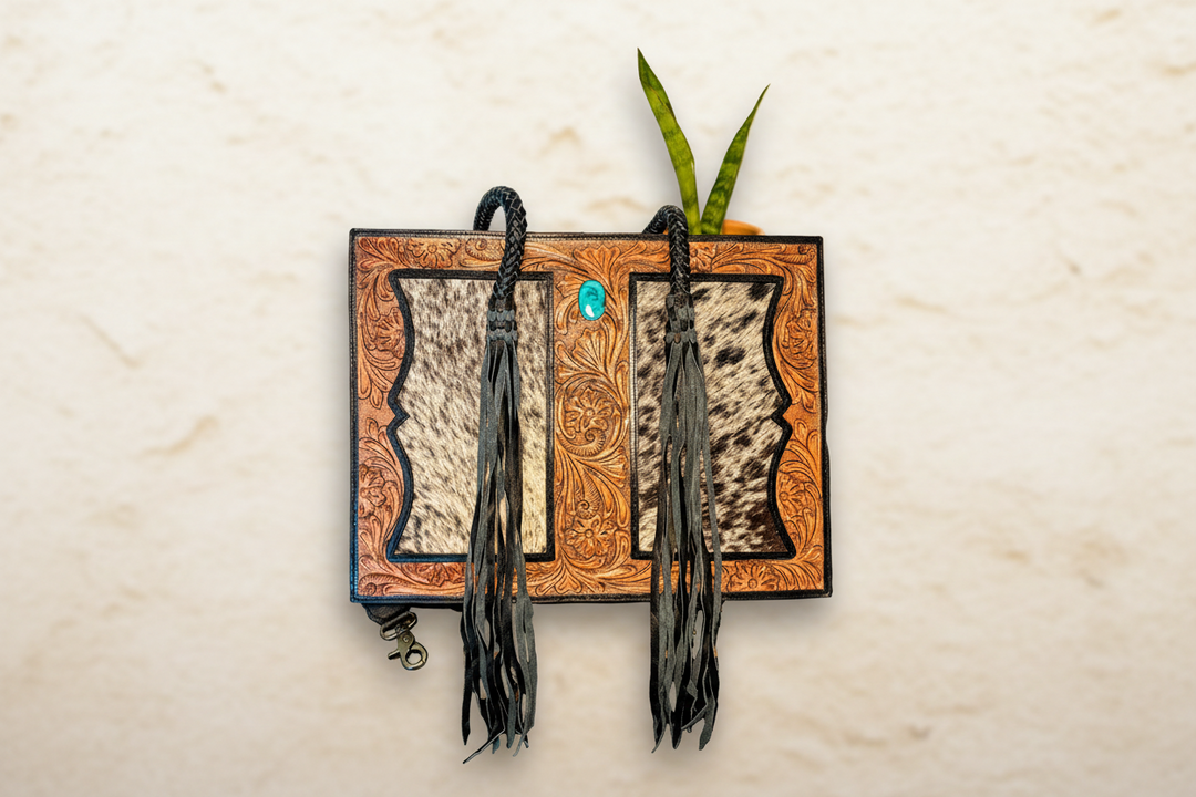 Western cowhide tote purse with tooled leather panels and turquoise concho detail