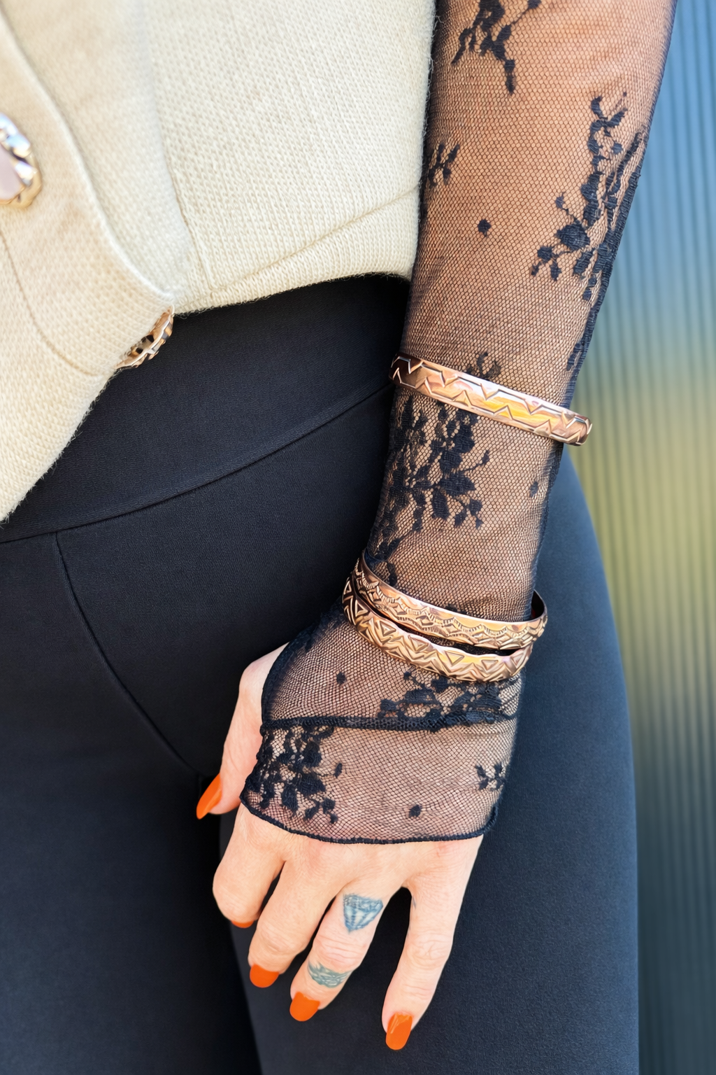Stacked Navajo copper cuffs styled on arm with black lace sleeve