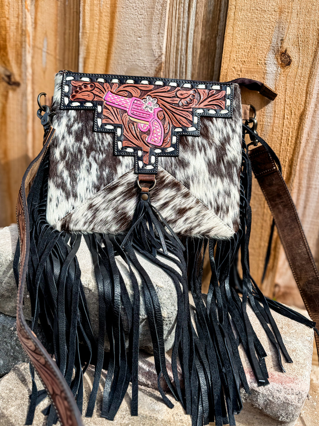 Cowhide concealed carry fringe crossbody bag with tooled leather top and pink pistol detail