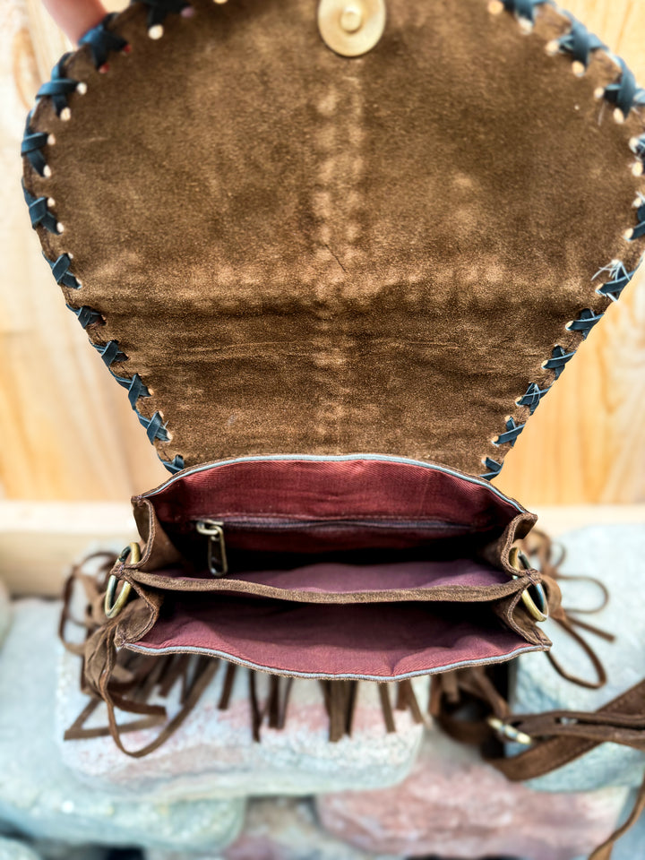 Interior view of suede crossbody bag with divided open compartments and back zipper pocket