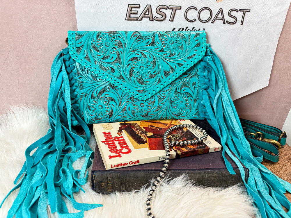 Turquoise tooled leather fringe crossbody styled with books and western jewelry