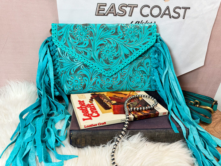 Turquoise tooled leather fringe crossbody styled with books and western jewelry