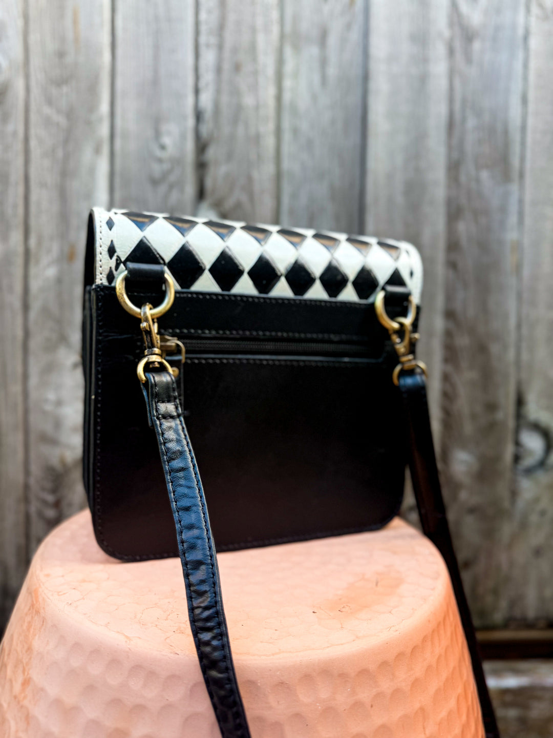 Back view of black leather Speed Check crossbody purse with exterior zipper pocket and adjustable strap