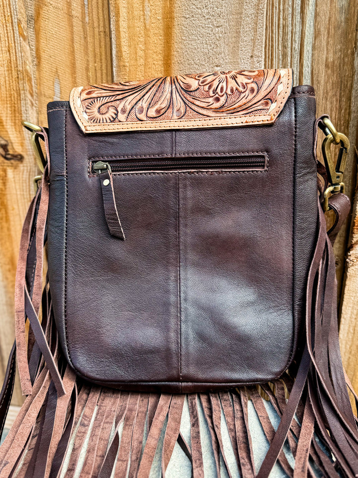 Back view of brown leather fringe purse with zipper pocket and tooled leather accent