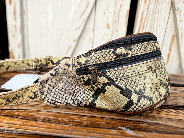 Butter yellow snake print genuine leather belt bag with adjustable strap and zipper pockets.