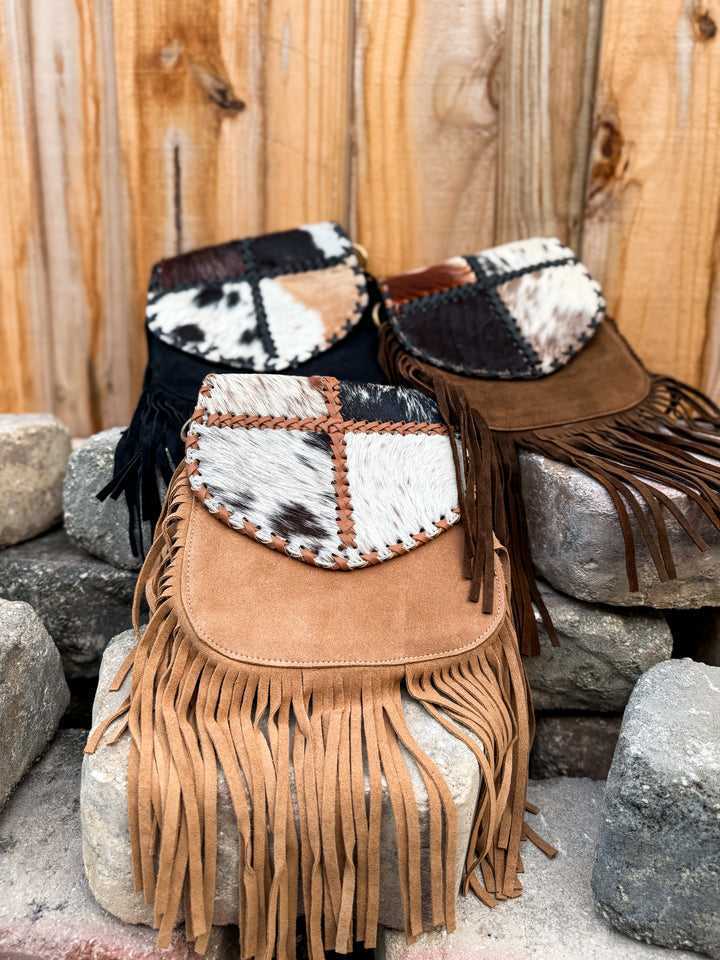 Three color options of patchwork cowhide fringe crossbody bags in black, tan, and brown