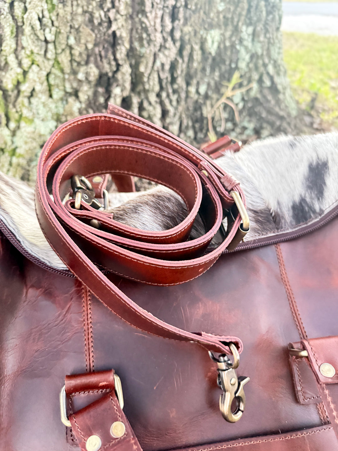 Removable leather crossbody strap with brass hardware on weekender
