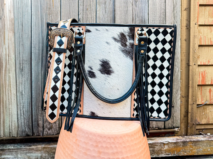 Handbag with cowhide leather and checkered pattern on a wooden background