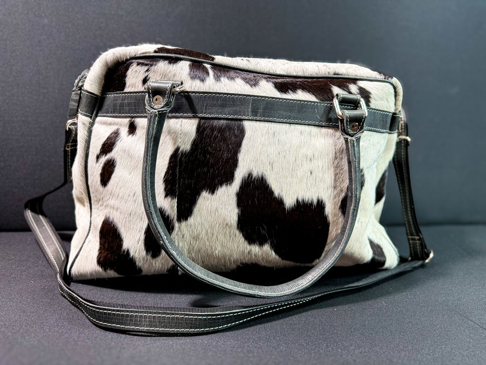 Back of black and white cowhide leather weekender bag western duffle purse with front pockets