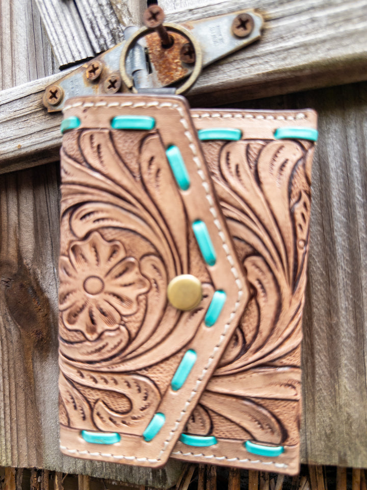Tooled leather keychain wallet with turquoise whipstitch detail and snap closure, front view.