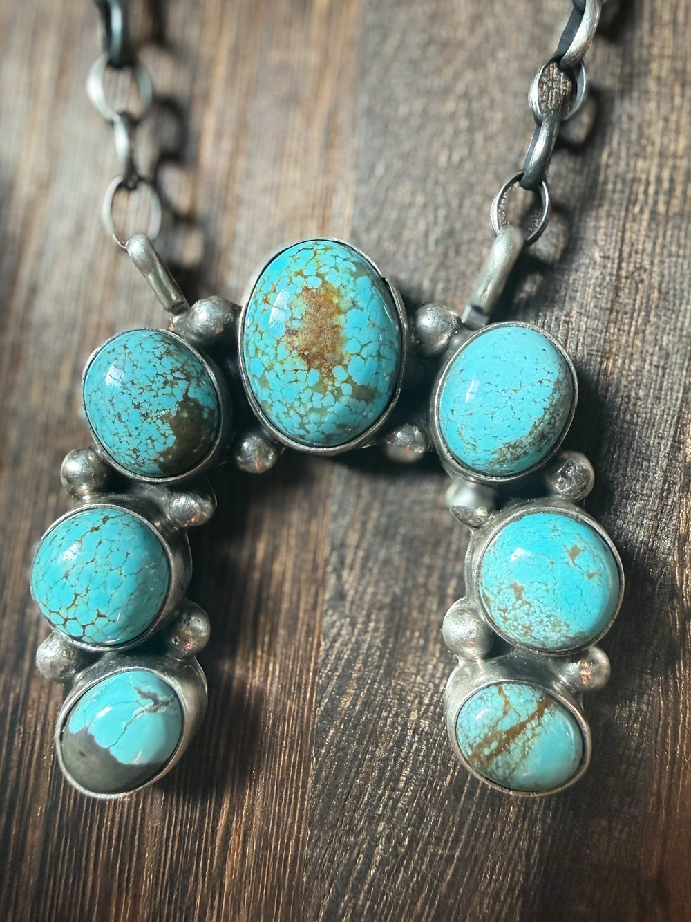 Close up of Navajo sterling silver naja necklace with mine 8 turquoise stones by Augustine Largo on 16 inch chain