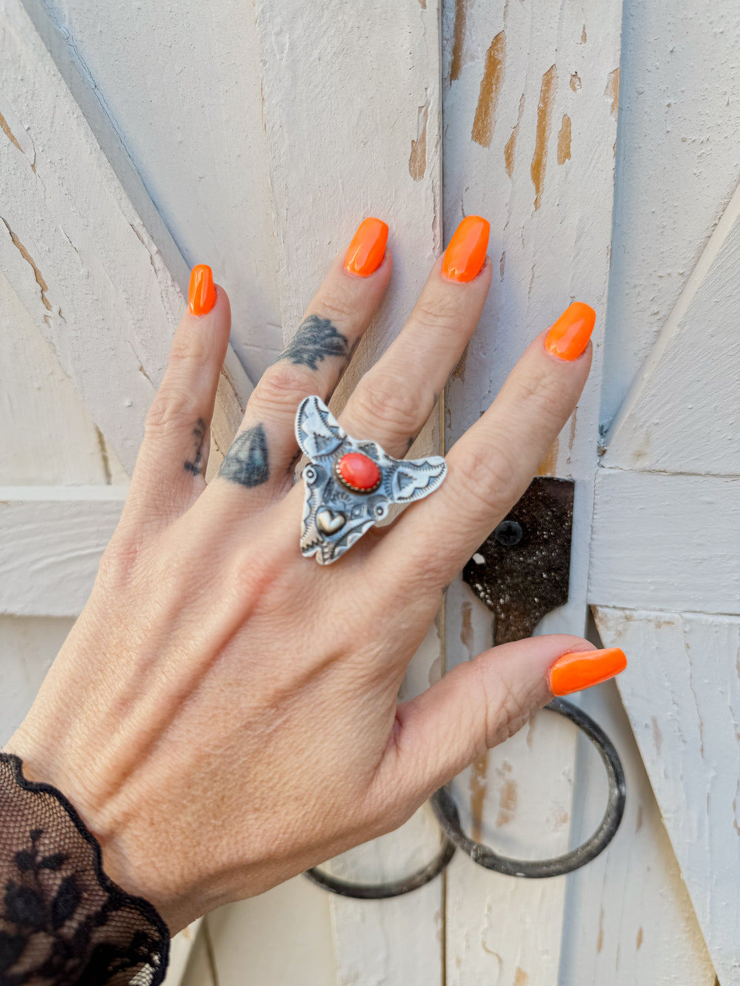 Woman wearing Navajo cow skull statement ring with spiny oyster stone and sterling silver