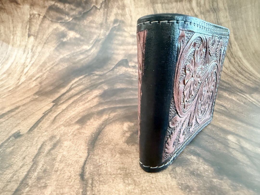 Side view of bifold wallet showing hand-tooled leather and stitching