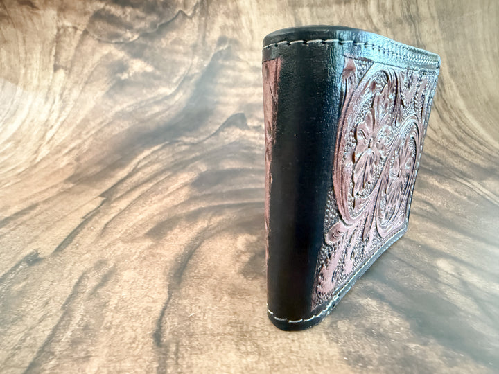 Side view of bifold wallet showing hand-tooled leather and stitching