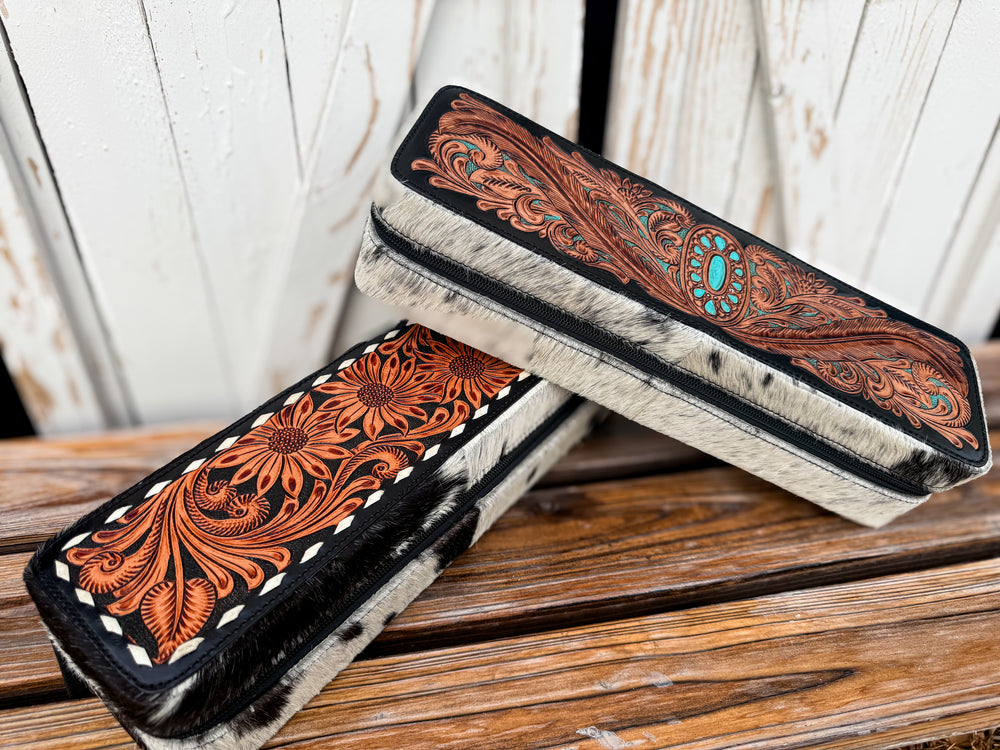 Handmade western cowhide hair tool case with floral tooled leather and zipper closure.