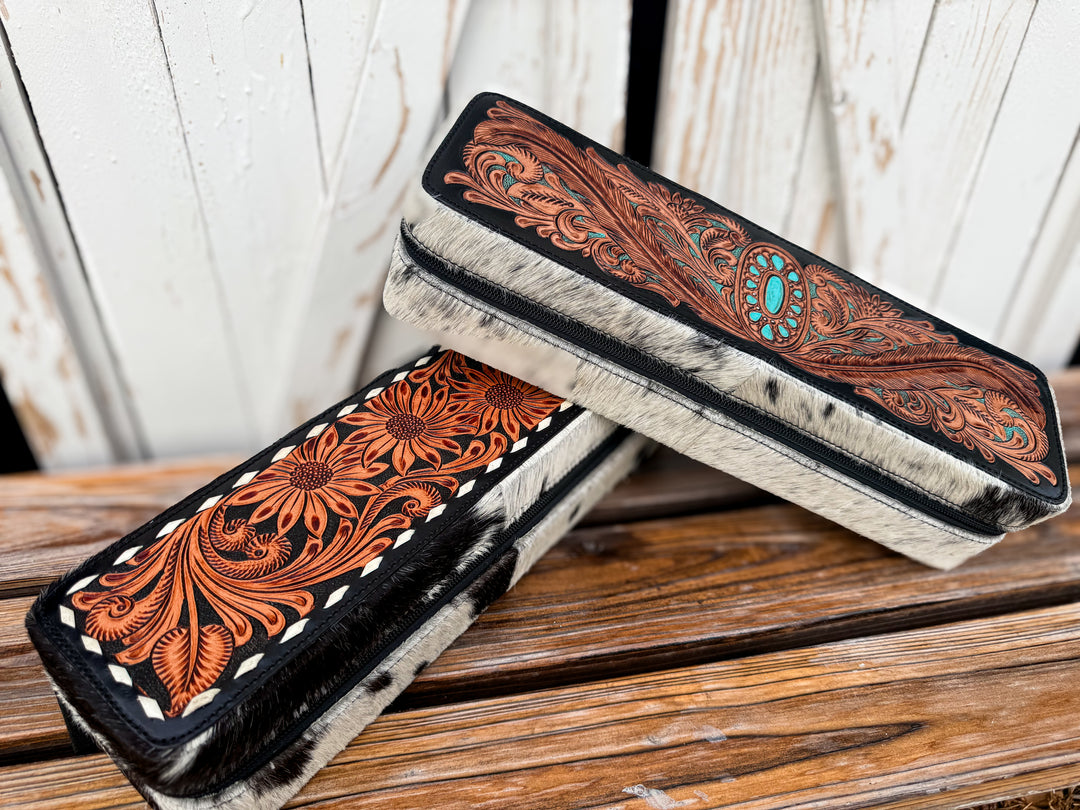 Handmade western cowhide hair tool case with floral tooled leather and zipper closure.