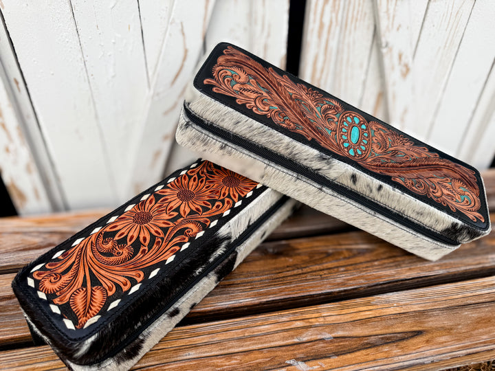 Handmade western cowhide hair tool case with floral tooled leather and zipper closure.